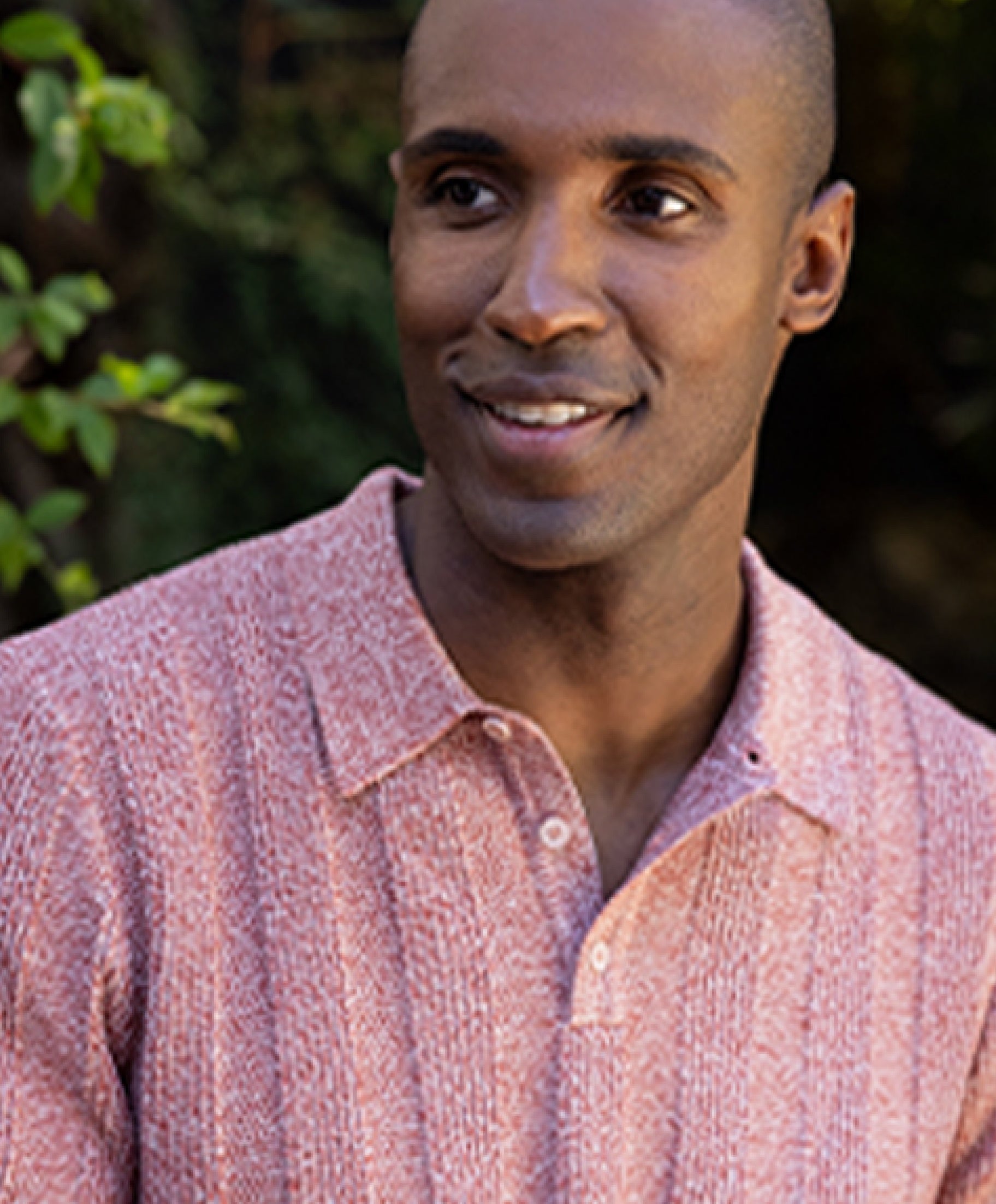 Man smiling wearing red shirt outdoors